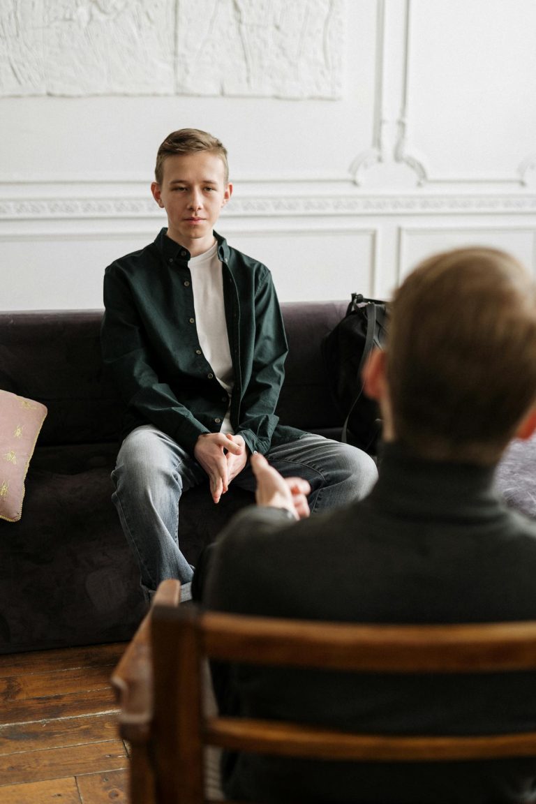 A therapy session with a therapist and patient conversing in a modern office setting.